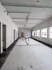 Construction site interior with laser leveling equipment and red laser lines projected on walls and ceiling. Voir les images du produit
