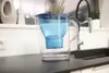 A water filter pitcher sits on a kitchen counter next to a sink. Náhled obrázku produktu