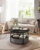 A living room scene featuring a round coffee table with a fabric basket underneath, placed in front of a sofa. The scene is well-lit and styled. Produktbild-Vorschau