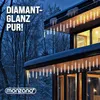 A modern house with icicles and string lights on the roof during winter. Produktbild-Vorschau