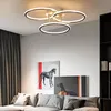 A modern living room with a sectional sofa, artwork on the wall, and a contemporary ceiling light fixture. Podgląd zdjęcia produktu