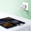 A white Belkin dual USB-C charger is plugged into a white wall socket, with two white charging cables connected to a tablet and a smartphone, which are placed on a white surface. Náhľad obrázku produktu