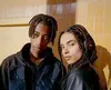 Two young people with braided hair are posing for a photo, looking at the camera. Voir les images du produit