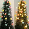 Two images of a Christmas tree decorated with colorful pom-pom string lights, one with lights off and one with lights on. Náhľad obrázku produktu