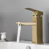 A close-up shot of a modern gold-colored bathroom faucet with water running from it. Náhľad obrázku produktu