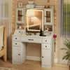A vanity table with a lighted mirror, drawers, and cabinets, set up in a bedroom next to a bed and a window. Podgląd zdjęcia produktu