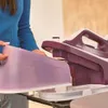 A person is holding a water tank for a steam iron. Produktbild-Vorschau
