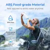 A man is drinking from a water filter bottle while hiking in a mountainous landscape. Anteprima dell’immagine prodotto