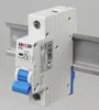 A close-up shot of a white electrical circuit breaker mounted on a metal rail. Produktbild-Vorschau