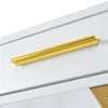 A close-up view of a gold drawer pull on a white surface, likely a piece of furniture. Anteprima dell’immagine prodotto