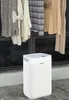 A white dehumidifier sits on a tiled floor in front of a window with clothes hanging to dry. Anteprima dell’immagine prodotto