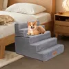 A small dog is lying on a set of pet stairs next to a bed. Produktbild-Vorschau