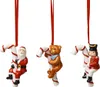 Three Christmas ornaments hanging from red ribbons against a white background. Podgląd zdjęcia produktu