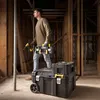 A man is standing in a construction site, holding a tool and looking to the side. There are toolboxes in the foreground. Anteprima dell’immagine prodotto