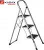 A silver stepladder with black anti-slip steps is shown against a white background. The KADAX WORKSHOP logo is visible in the top left corner. Podgląd zdjęcia produktu