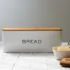 A white bread box with a wooden lid sits on a white tiled surface. Podgląd zdjęcia produktu