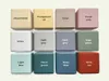 A grid of 12 wooden blocks, each labeled with a different color or finish. Produktbild-Vorschau