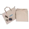 A beige travel bag with accessories and a folded beige item next to it. Produktbild-Vorschau