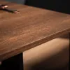 Close-up of a wooden tabletop with a dark metal frame visible underneath. Náhled obrázku produktu