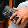 A person is holding a black phone case with a kickstand in a car. Produktbild-Vorschau
