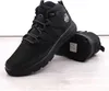 A pair of black boots on a light-colored wooden surface. Voir les images du produit