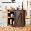 A dark brown wooden buffet cabinet with sliding barn doors is shown in a kitchen setting with white tiled walls. The cabinet is filled with various items, and there are labels highlighting its features. Podgląd zdjęcia produktu