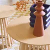 Two round wooden tables with a decorative object and a vase on top, placed on a rug. Produktbild-Vorschau