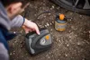 A person is using a tire sealant and inflator kit next to a car tire. Produktbild-Vorschau