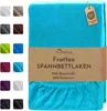 A turquoise fitted sheet is shown folded, with a swatch of other available colors on the left side of the image. A brown tag with product information is attached to the sheet. Produktbild-Vorschau