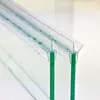 Close-up of a clear plastic shower door seal with water droplets on it, attached to two pieces of green-tinted glass. Podgląd zdjęcia produktu
