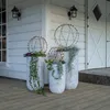 Three decorative spheres with lights on planters on a wooden porch in front of a white house. Produktbild-Vorschau