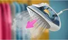 Close-up of a steam iron emitting steam, with a pink arrow indicating the steam direction. Blurred clothing is visible in the background. Anteprima dell’immagine prodotto