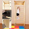 A young girl is climbing a wooden wall-mounted gym ladder indoors, with inset images showing details of the product. Produktbild-Vorschau