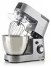A silver and gray kitchen mixer with a whisk attachment and a clear splash guard is shown against a white background. Podgląd zdjęcia produktu