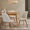 A dining set with four chairs and a wooden table in a well-lit room with a textured wall. Produktbild-Vorschau