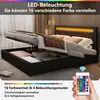 A bed with its storage compartment open, showing stored items, and a remote control for LED lighting. Produktbild-Vorschau