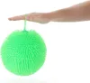 A hand holding a green puffer ball. Produktbild-Vorschau