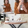 A collage of images showing a child playing with a toy ironing board set, and a close-up of the toy ironing board set. Produktbild-Vorschau