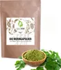 A bag of moringa powder with a bowl of moringa powder and leaves in front of it. Produktbild-Vorschau