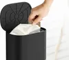 A hand is placing a dust bag into a black trash can. Produktbild-Vorschau