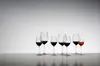 A collection of wine glasses filled with red wine, arranged on a reflective surface against a gradient background. Produktbild-Vorschau