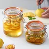 Two glass jars filled with sliced lemons and passion fruit, with a person slicing a lemon in the background. Anteprima dell’immagine prodotto