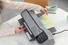 A person is using a laminating machine to laminate a document. Anteprima dell’immagine prodotto
