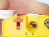 A close-up of a yellow wire stripping tool with a red lever, held by a person's finger. Produktbild-Vorschau