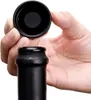 A hand is holding a black bottle cap above a black bottle neck, preparing to seal it. Anteprima dell’immagine prodotto