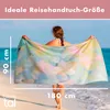 A woman on a beach holding a large, colorful towel. Podgląd zdjęcia produktu