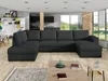 A spacious living room with a large sectional sofa, coffee table, and a view of the outdoors through large windows. Náhled obrázku produktu