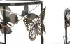 Close-up of decorative metal butterflies on a table leg. Produktbild-Vorschau
