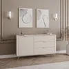A beige sideboard with gold accents is displayed in a room with two framed abstract art pieces on the wall. Produktbild-Vorschau