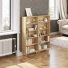 A wooden bookshelf filled with books and decorative items, placed in a room with a window and a radiator. Produktbild-Vorschau